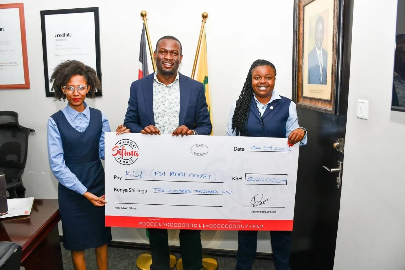 Sen. Edwin Sifuna presenting a cheque to Kenya School of Law students.