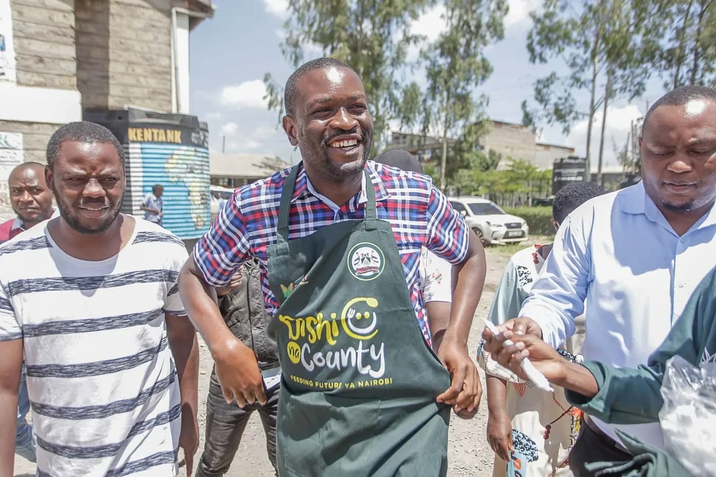 Sen. Edwin Sifuna in a Dishi na County apron at a school feeding event.