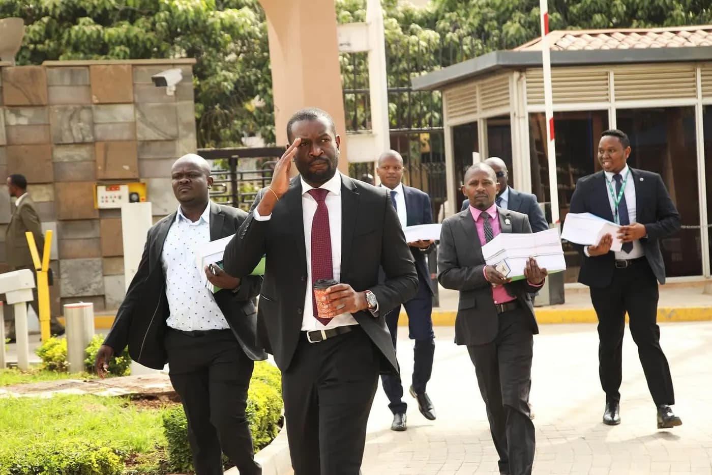 Sen. Edwin Sifuna leading aides carrying stacks of documents.