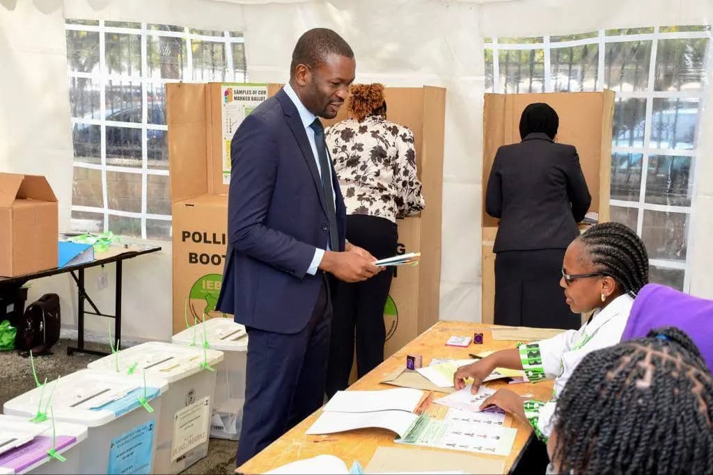 Sen. Edwin Sifuna at a polling station, ballot papers in hand.