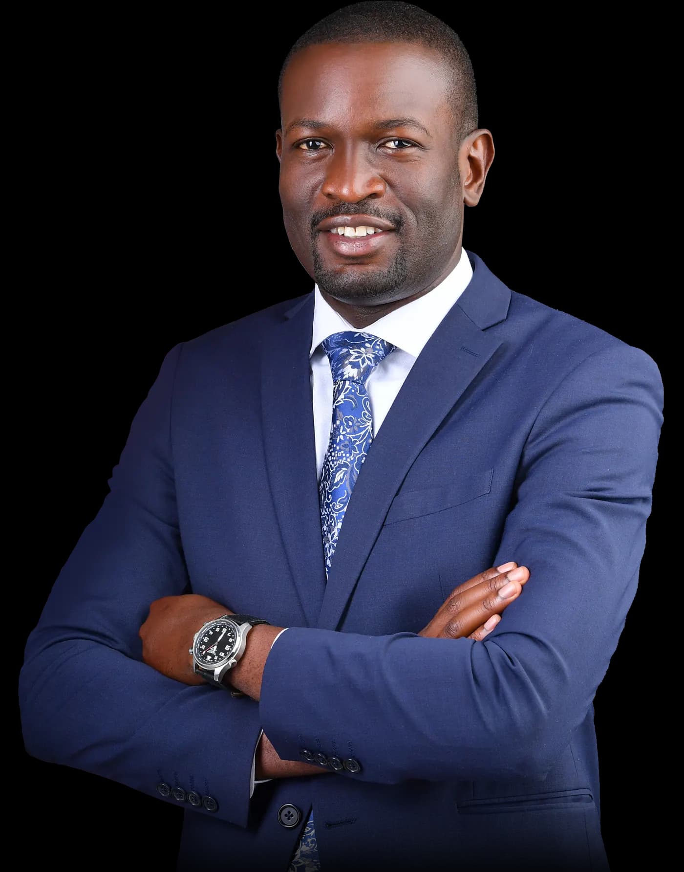 Hon. Edwin Sifuna standing with his arms crossed, wearing a navy suit and patterned blue tie.