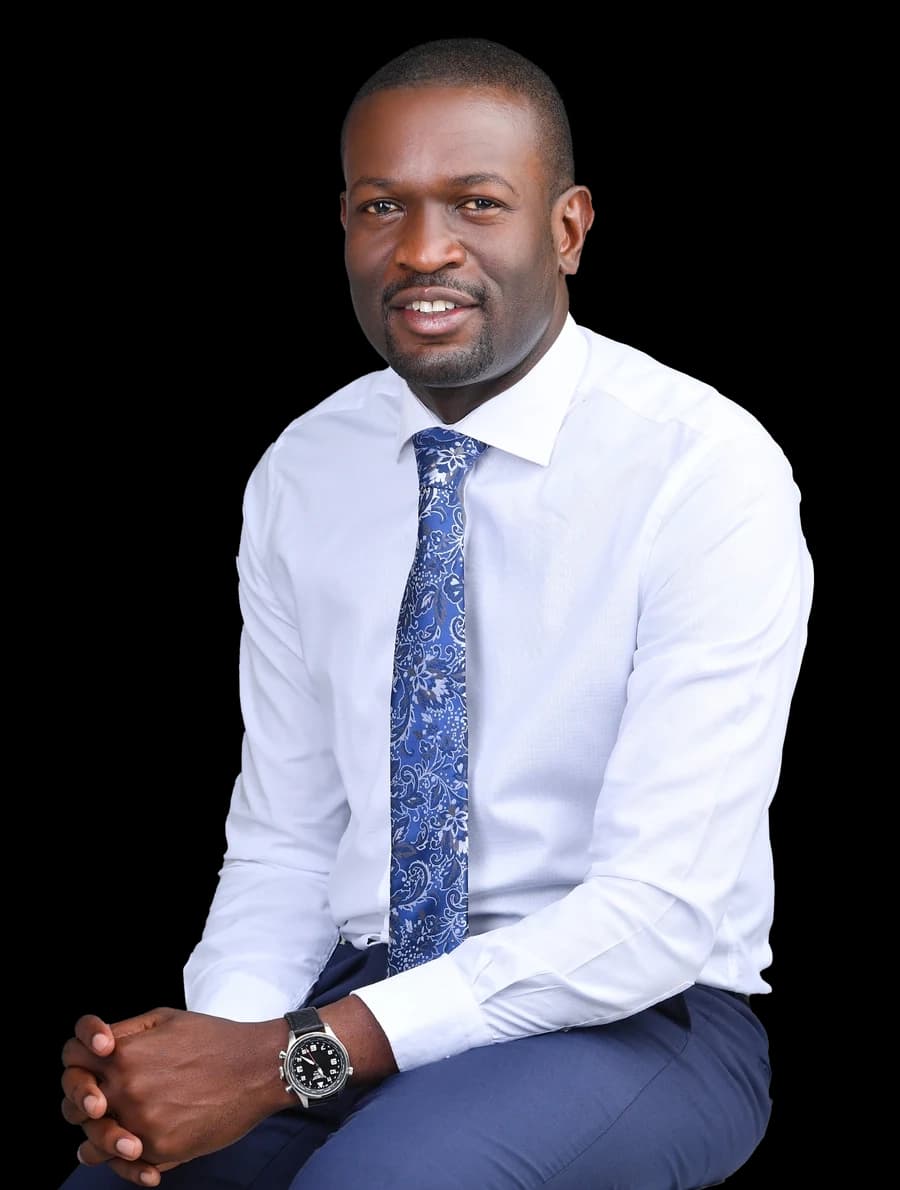 Hon. Edwin Sifuna seated, wearing a white shirt and patterned blue tie.